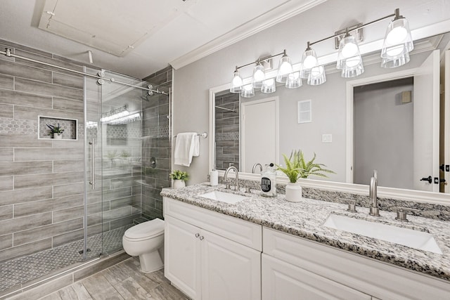 bathroom featuring an enclosed shower, vanity, ornamental molding, and toilet