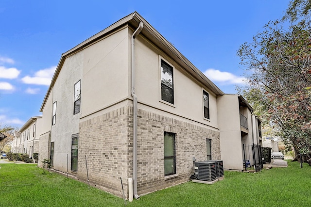 view of home's exterior featuring central AC unit and a lawn