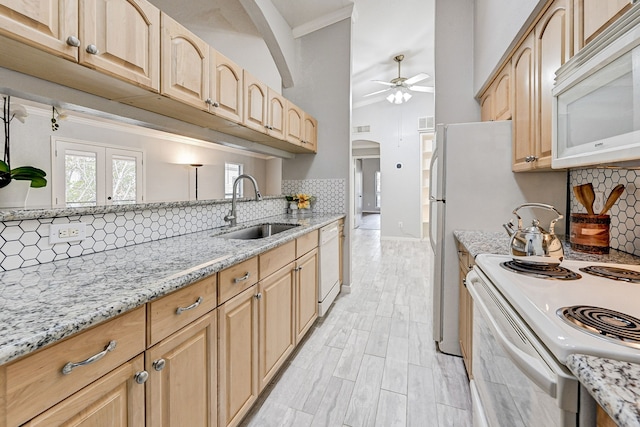 kitchen featuring light stone countertops, sink, light brown cabinetry, and white appliances