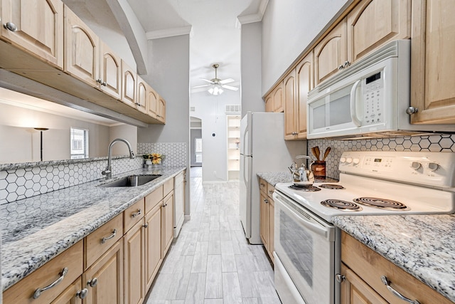 kitchen with sink, ceiling fan, light stone counters, crown molding, and white appliances