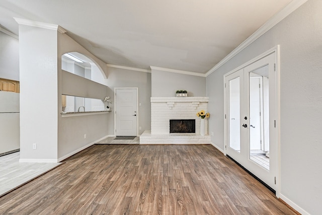 unfurnished living room featuring a fireplace, crown molding, and wood-type flooring