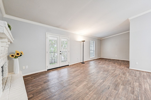 unfurnished living room with wood-type flooring, ornamental molding, a fireplace, and french doors