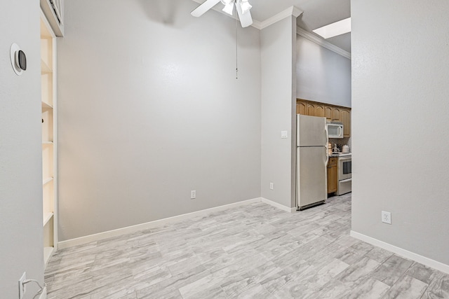 empty room with crown molding, light hardwood / wood-style flooring, ceiling fan, and a towering ceiling