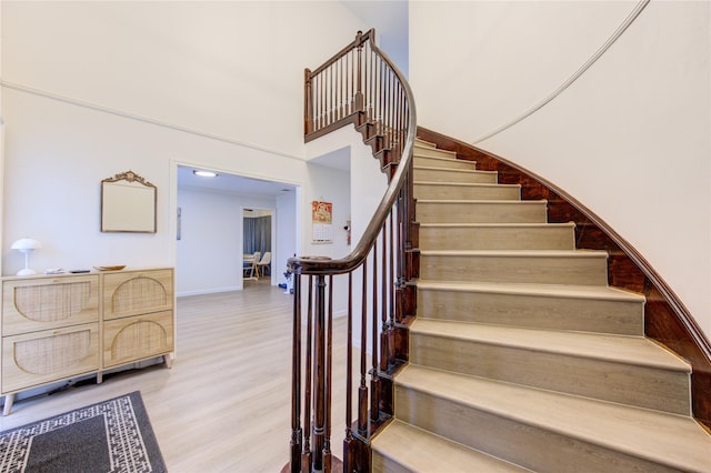 stairway featuring a high ceiling and hardwood / wood-style floors