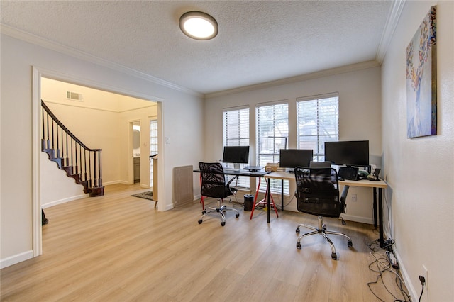 office area with ornamental molding, a textured ceiling, and light wood-type flooring