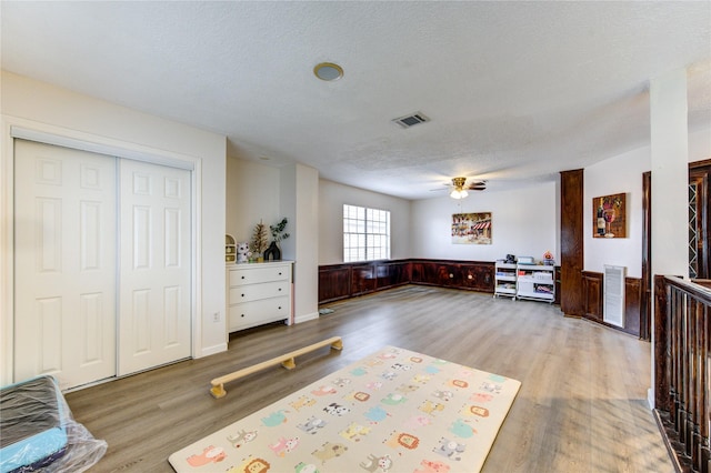 interior space featuring ceiling fan, light hardwood / wood-style floors, and a textured ceiling