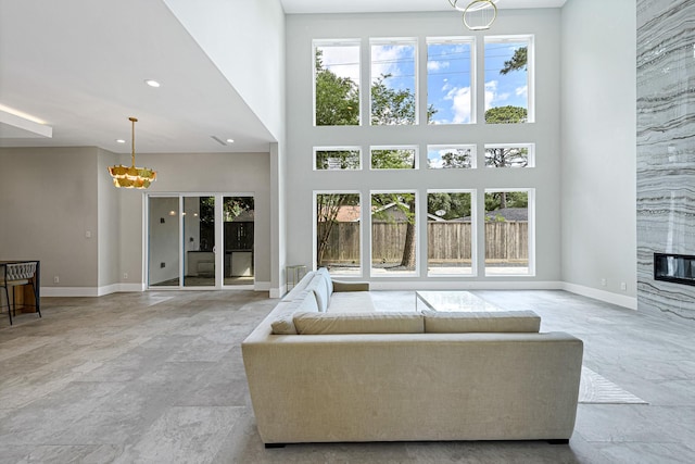 living room with a high ceiling, a wealth of natural light, and a fireplace