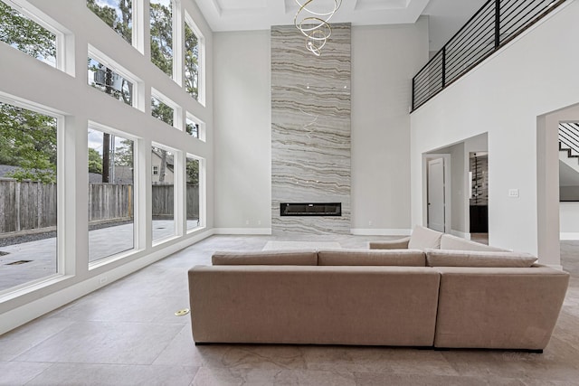 unfurnished living room with plenty of natural light, a premium fireplace, and a chandelier