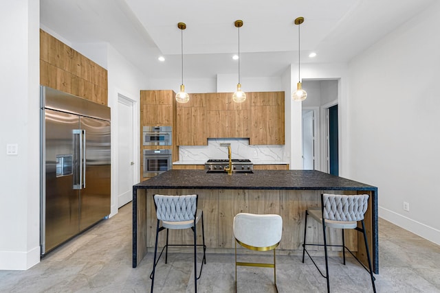 kitchen featuring pendant lighting, appliances with stainless steel finishes, a breakfast bar, and decorative backsplash