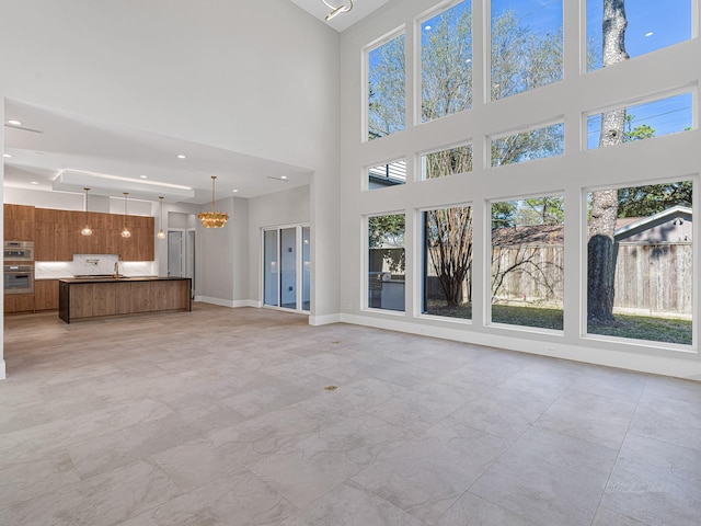 unfurnished living room featuring an inviting chandelier