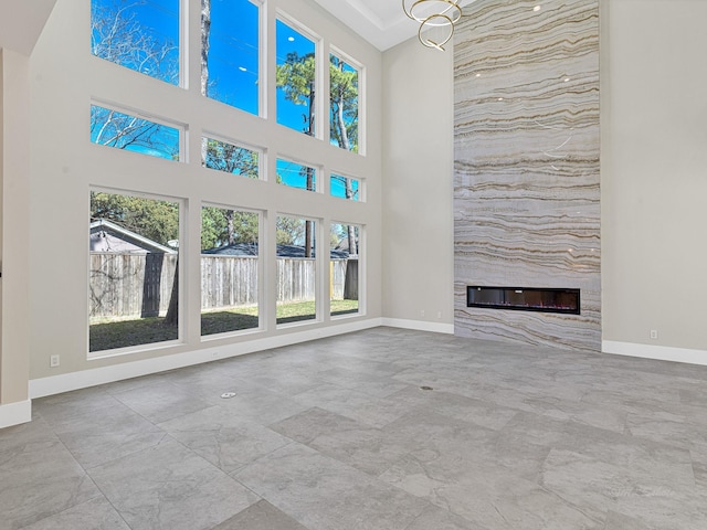 unfurnished living room with a fireplace and a high ceiling