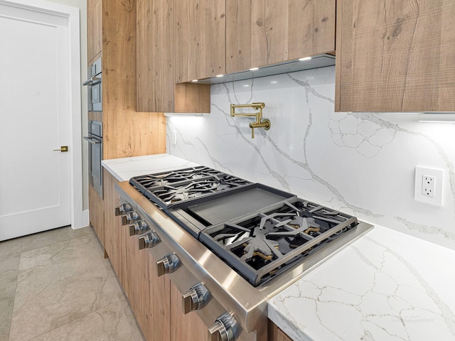 kitchen featuring stainless steel gas stovetop and decorative backsplash