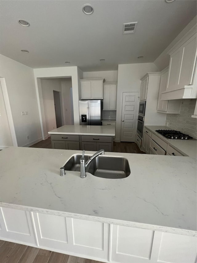 kitchen featuring white cabinetry, appliances with stainless steel finishes, a center island, and sink