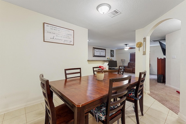 dining room featuring ceiling fan, a textured ceiling, and light tile patterned floors