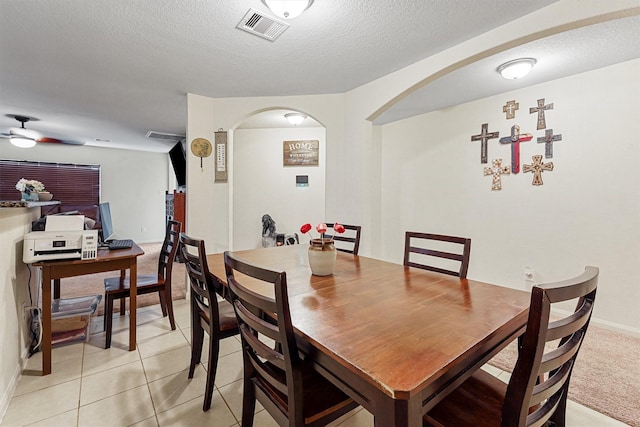 dining area featuring light tile patterned flooring, ceiling fan, and a textured ceiling