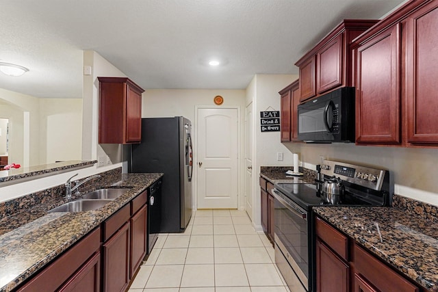 kitchen featuring light tile patterned floors, dark stone counters, sink, and black appliances