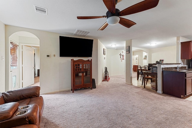 living room featuring light colored carpet and ceiling fan