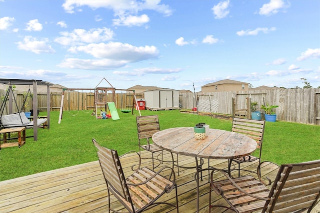 deck with a storage unit, a playground, and a lawn