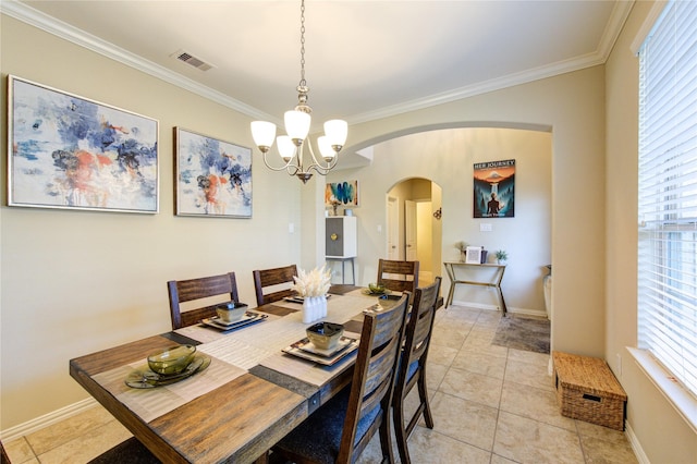 dining area featuring an inviting chandelier, ornamental molding, and light tile patterned floors