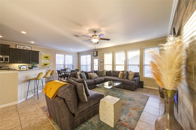 living room with ceiling fan, ornamental molding, and light tile patterned floors