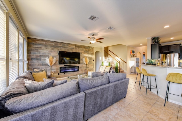 tiled living room with crown molding and ceiling fan