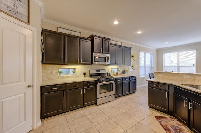 kitchen featuring light stone counters, dark brown cabinetry, appliances with stainless steel finishes, and decorative backsplash