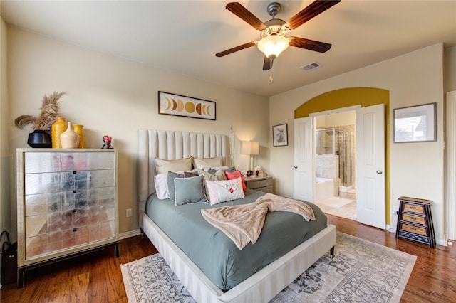 bedroom with dark wood-type flooring, ceiling fan, and ensuite bathroom