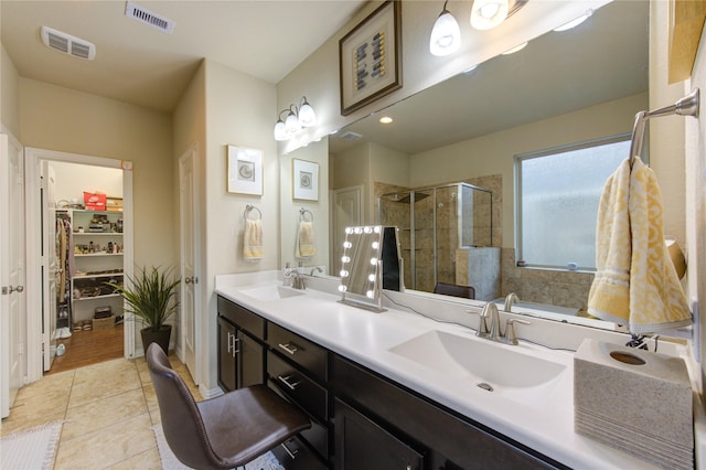 bathroom featuring vanity, a shower with shower door, and tile patterned floors