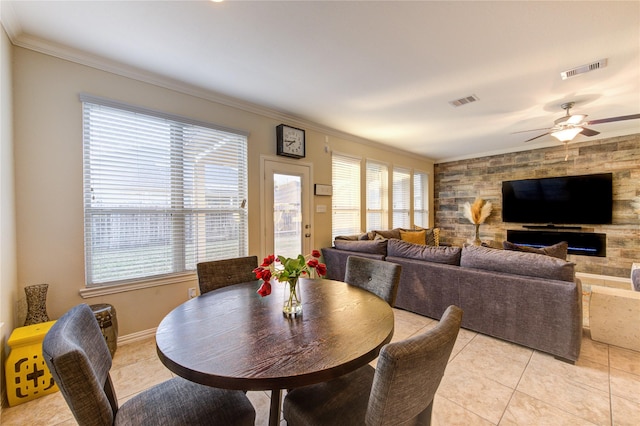 dining area with light tile patterned floors, crown molding, and ceiling fan