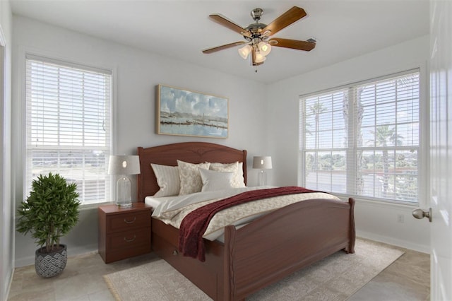 bedroom featuring multiple windows, light tile patterned floors, and ceiling fan