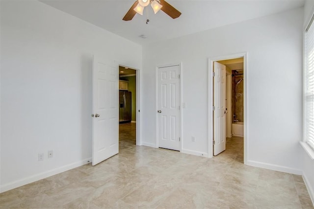 unfurnished bedroom featuring ceiling fan, connected bathroom, and stainless steel fridge