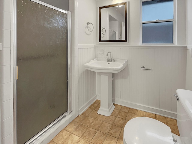 bathroom featuring tile patterned flooring, sink, an enclosed shower, and toilet