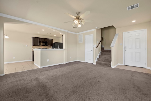 unfurnished living room featuring crown molding, light colored carpet, and ceiling fan