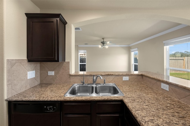 kitchen featuring tasteful backsplash, dishwasher, sink, and crown molding