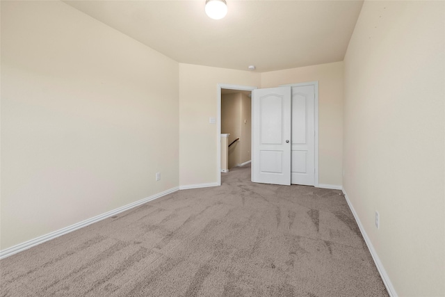 unfurnished bedroom with light carpet and a closet