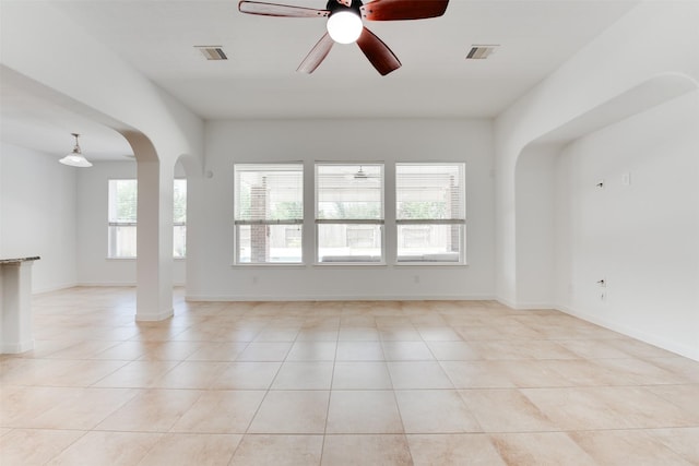 tiled spare room with ceiling fan