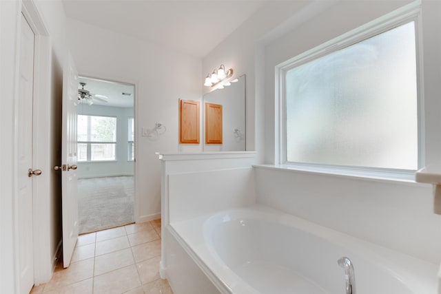 bathroom featuring tile patterned flooring, ceiling fan, and a tub to relax in