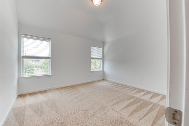 unfurnished room with lofted ceiling and light carpet