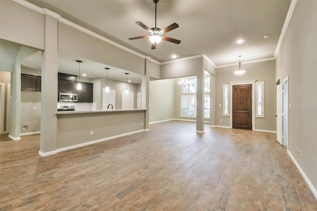 unfurnished living room with crown molding, sink, hardwood / wood-style flooring, and ceiling fan