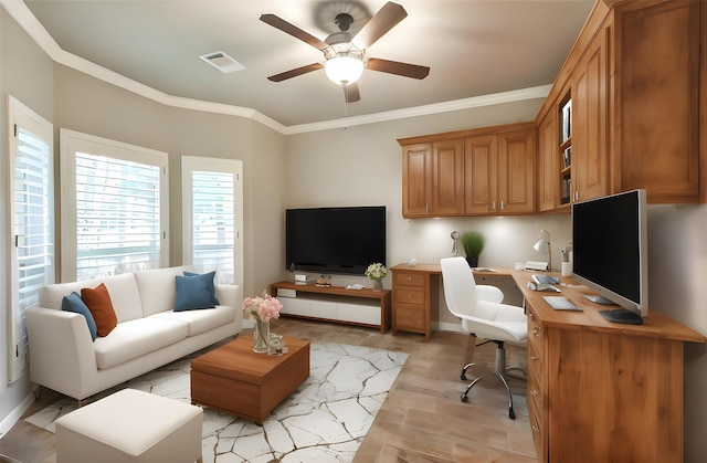 office space featuring crown molding, built in desk, and ceiling fan