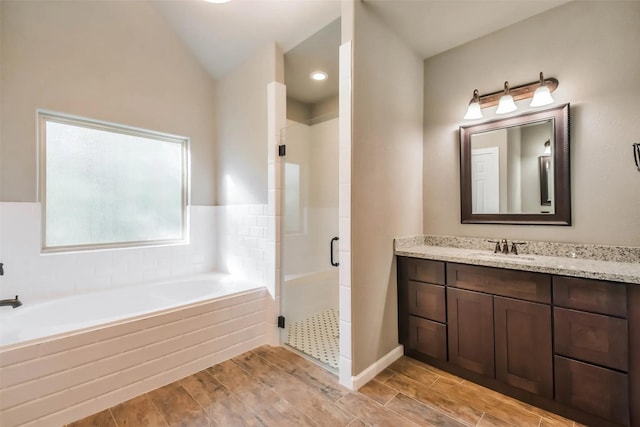 bathroom with lofted ceiling, separate shower and tub, and vanity