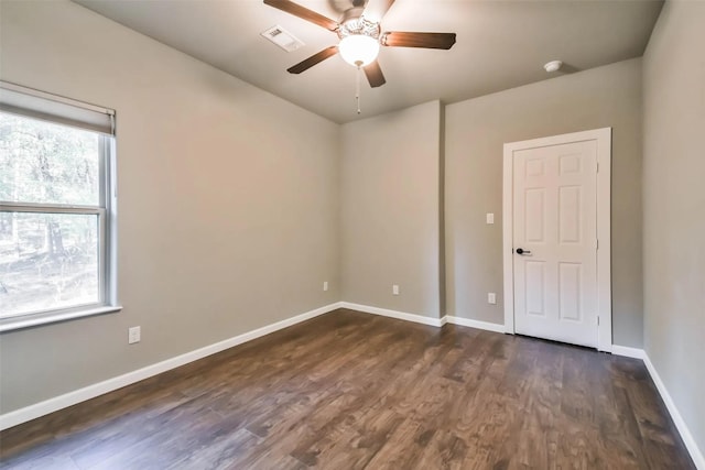 empty room with ceiling fan and dark hardwood / wood-style flooring