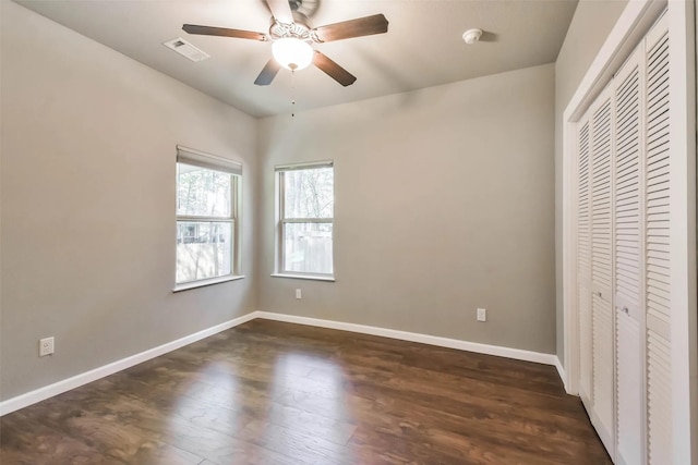 unfurnished bedroom featuring ceiling fan, dark hardwood / wood-style flooring, and a closet