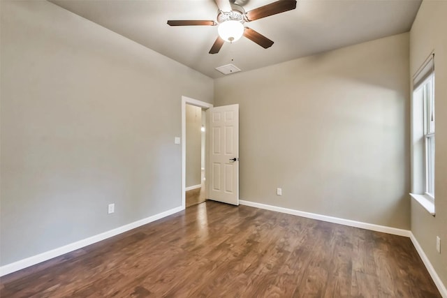 empty room with ceiling fan, plenty of natural light, and dark hardwood / wood-style flooring