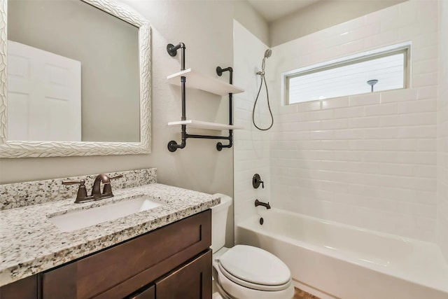 full bathroom featuring tiled shower / bath, vanity, and toilet