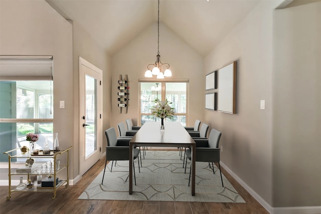 dining room featuring high vaulted ceiling, hardwood / wood-style floors, and an inviting chandelier