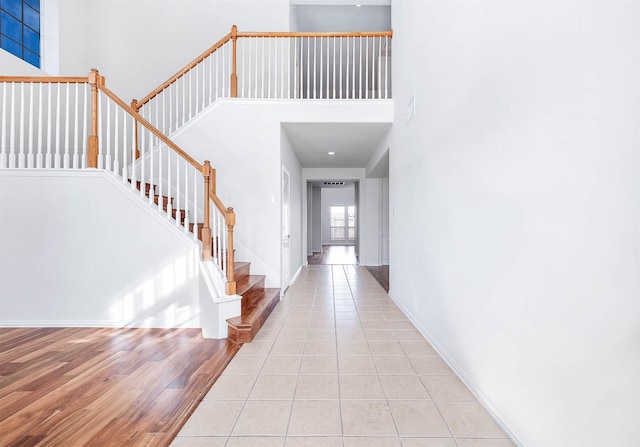 entryway featuring light tile patterned floors and a towering ceiling