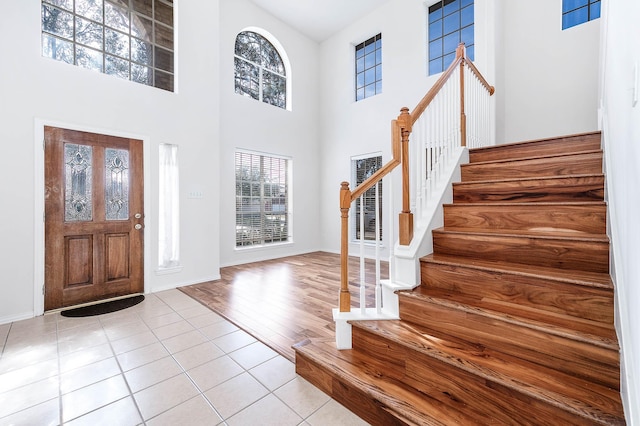 foyer entrance with a towering ceiling and light tile patterned floors