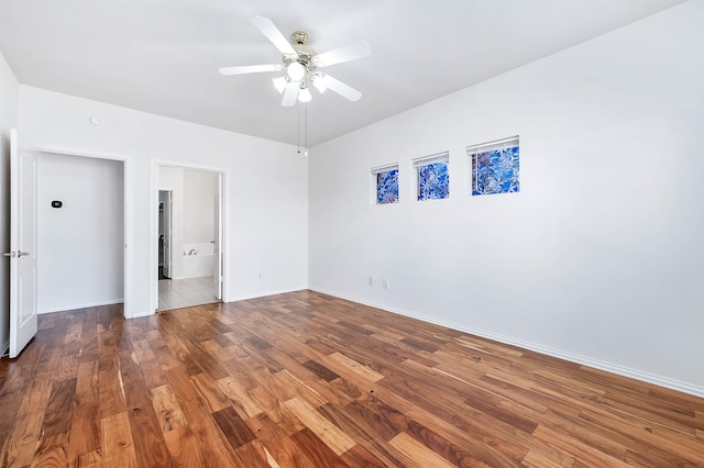 empty room with dark hardwood / wood-style flooring and ceiling fan