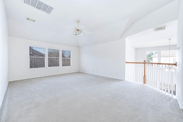 carpeted spare room featuring ceiling fan and lofted ceiling